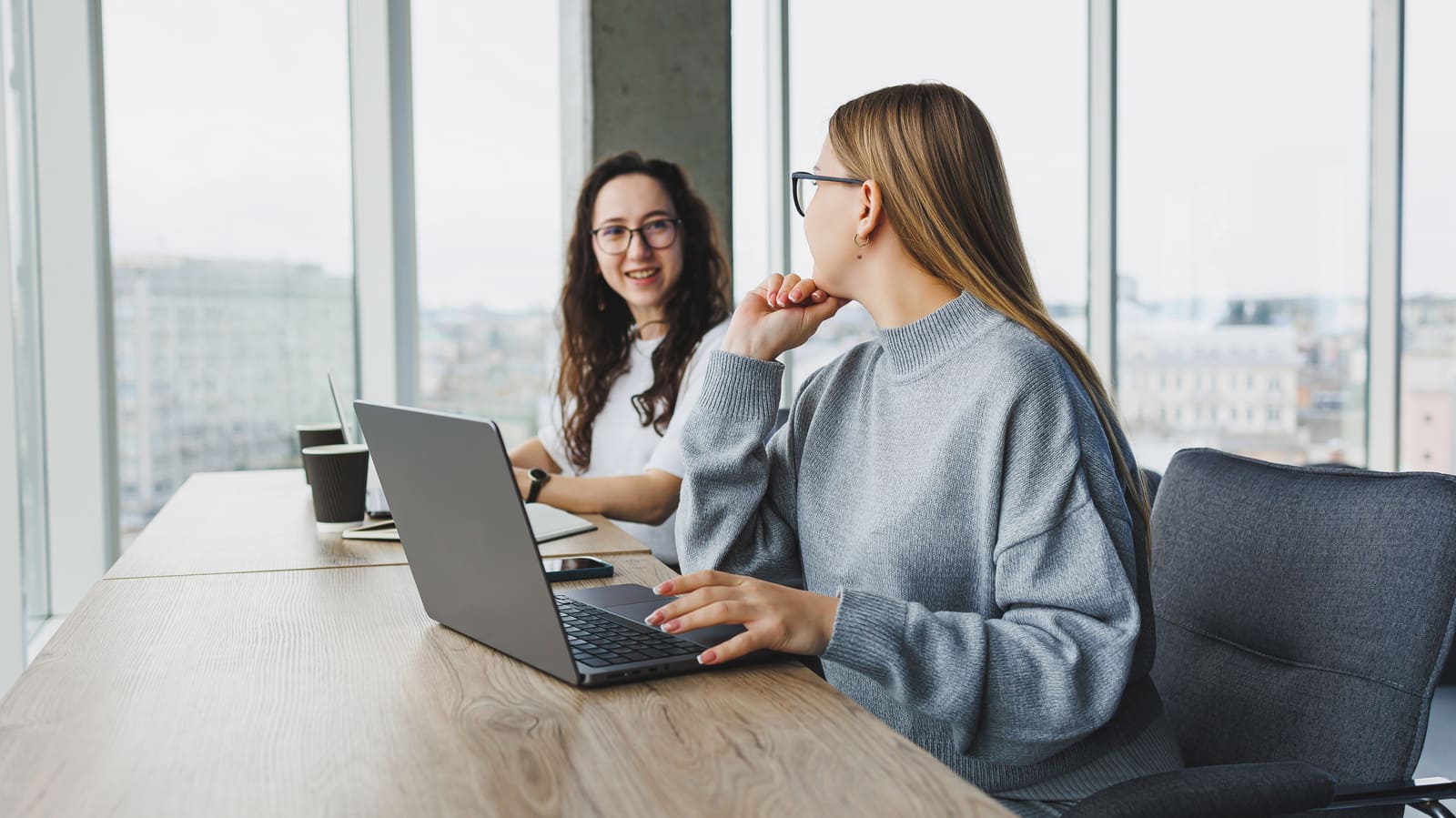 beautiful-two-young-confident-business-women-sitting-office-room-working-laptop-computer-work-colleagues-modern-office Evaluating Results and Making Decisions